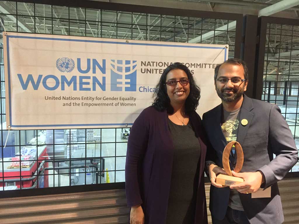 A photo of me with the Executive Director of Rape Victim Advocates. I'm holding my Gender Equality Award and hand-carved wooden sculpture, and we're standing in front of a banner that reads 